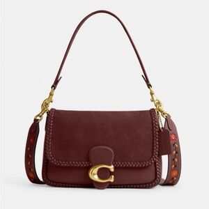 Cute Burgundy coach tabby with gorgeous strap 
Small stain on front